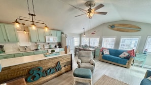 A spacious living area with a kitchen, a dining table, and a sofa.