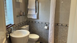 Ein Badezimmer mit Toilette, Waschbecken und Duschvorhang.