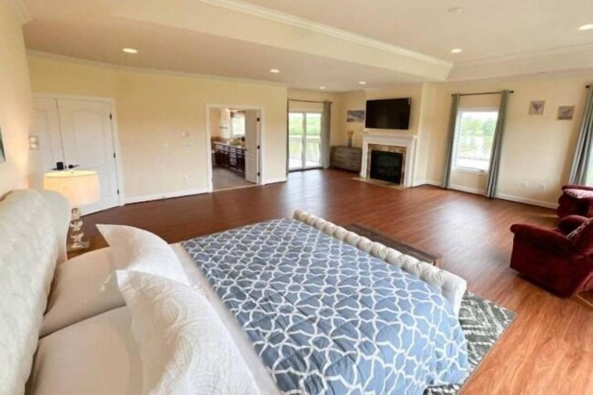 A spacious living room with a fireplace, a sofa, and a TV.