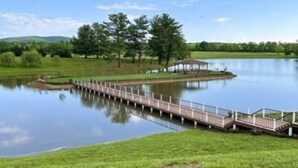 Un ponte di legno sopra un lago calmo, con un gazebo all'estremità.