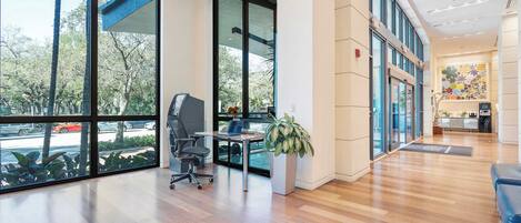 A spacious office with large windows, a reception area, and a modern interior design.