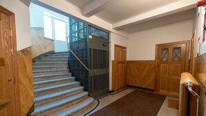 Eine Treppe mit Handlauf, einer Holztür und einem Teppichboden.