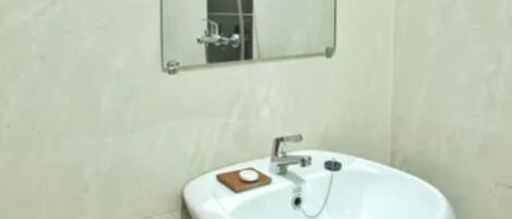 A bathroom with a white sink, a mirror, and a shower.
