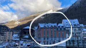 A building with a row of windows and a snow-covered mountain in the background. - Idéal Cure thermale à Cauterets - Near thermal baths & town center, 32 m² T2 (Cauterets)