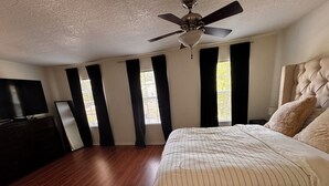 A bedroom with a large bed, a ceiling fan, and a TV on a dresser. - 3-bedroom townhome in charming Riverview with WiFi, AC. Relax and unwind (Riverview)