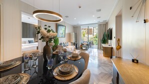 Un espace repas moderne avec une table noire dressée pour un repas, entourée de sièges confortables.