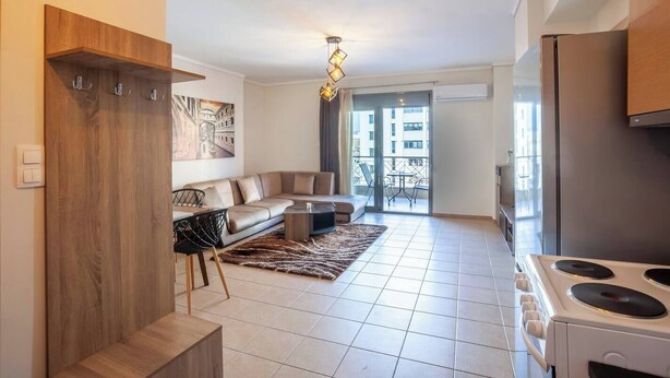Eine moderne Wohnung mit Wohnzimmer, Küche und Balkon.