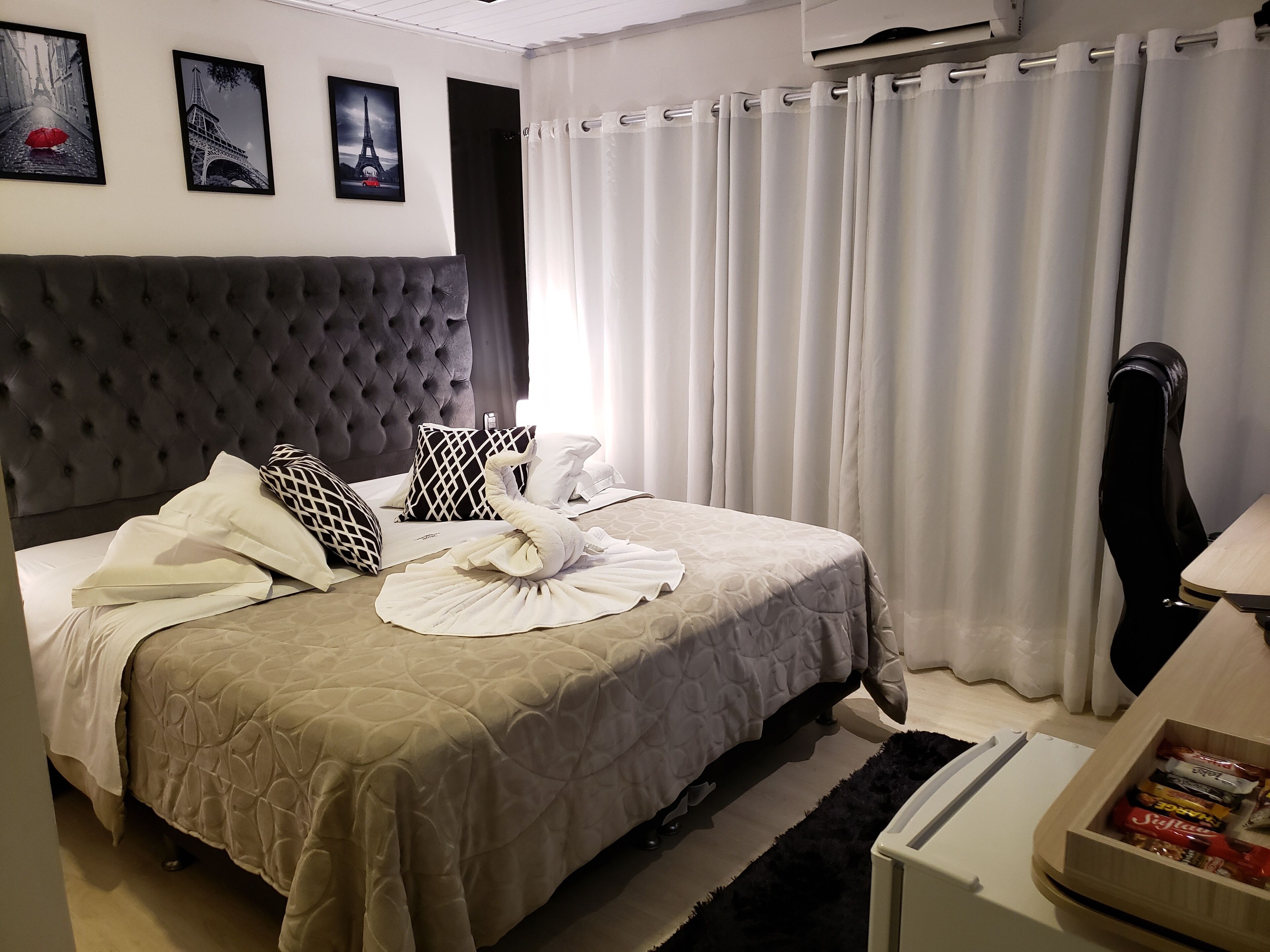 A neatly made bed with a tufted headboard, white bedding, and decorative pillows.