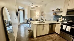 Una cocina moderna con suelo de madera, una isla central, un microondas y una estufa.