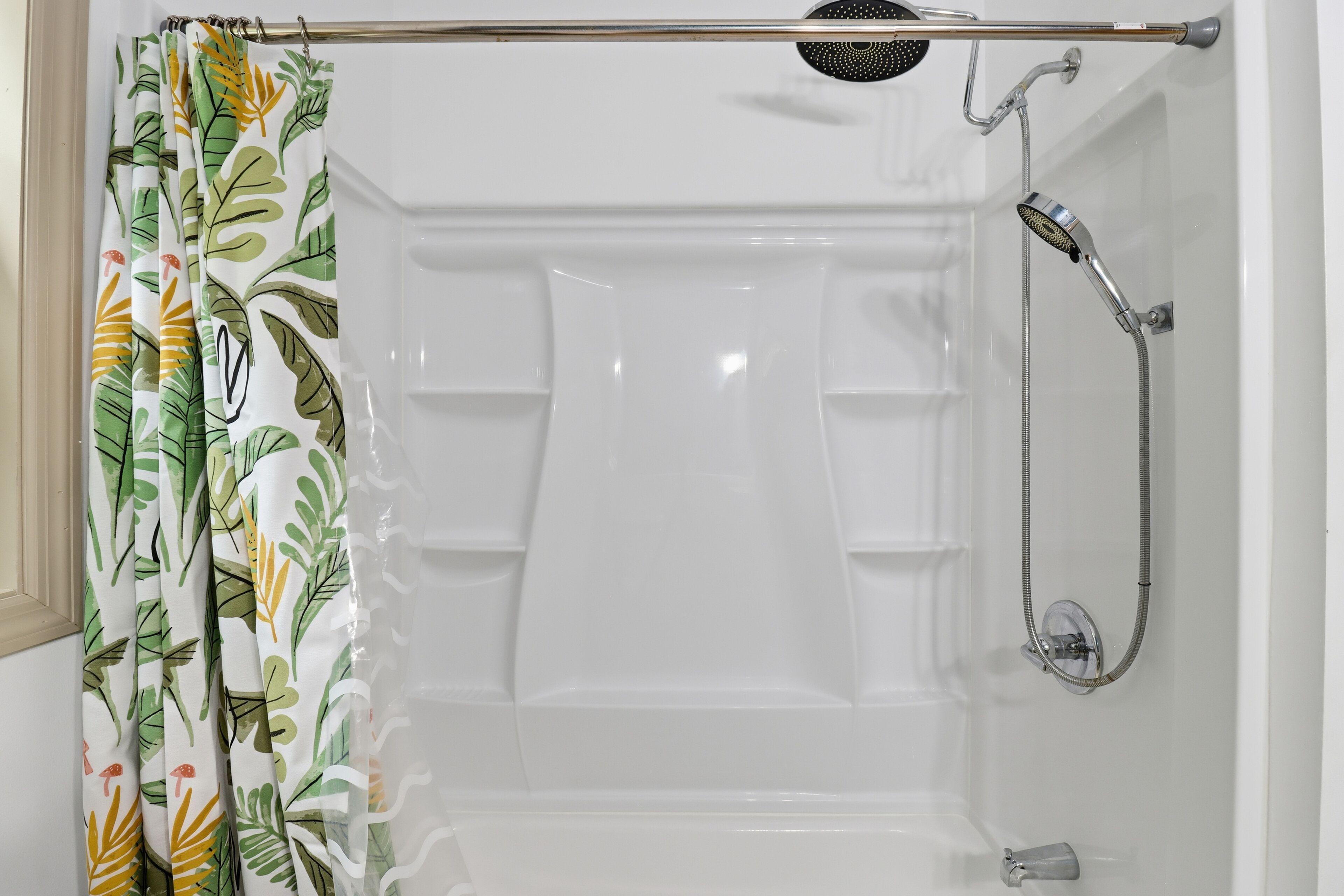 Une douche équipée d’un pommeau de douche à main et d’un flexible de douche.
