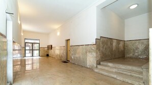 A spacious hallway with marble flooring and steps leading to an upper level. - Elegant apartment (Catania)