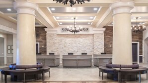 A lobby with a reception desk, two large columns, a patterned floor, and a chandelier. - Lovely Las Vegas 1BD Suite Near the Strip! (Las Vegas)