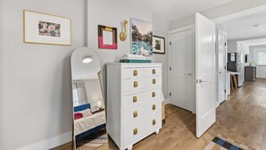 A modern bedroom with a bed, dresser, and a mirror. - Optimist Abode 2: Chic Stay in the Queen City, walking distance to Optimist Hall (Charlotte)