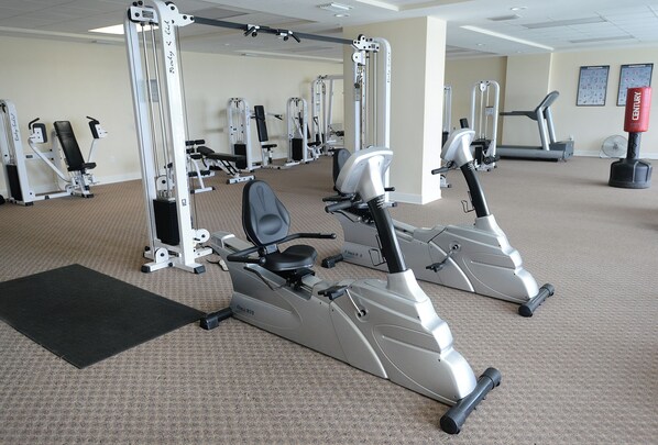 A gym with stationary bikes, weight machines, and a treadmill. - Beachfront Condo with Amazing Views and Beach Service Included! (Panama City)