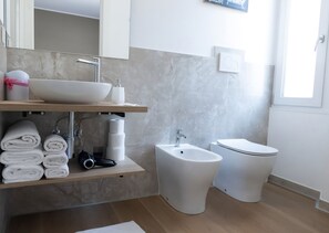 A modern bathroom with a sink, bidet, toilet, and a towel rack. - Il Giardino di Gioia (Verona)