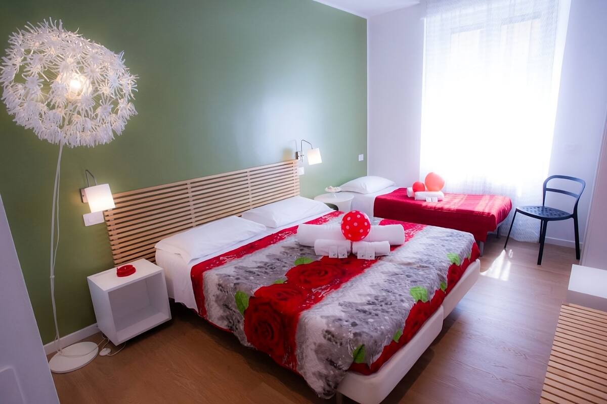 Ein ordentlich eingerichtetes Schlafzimmer mit einem großen Bett, Nachttischen, einer Lampe und einem Sessel.