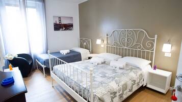A hotel room with a large bed, two bedside tables, a desk, and a chair.