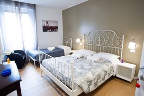 A hotel room with a large bed, two bedside tables, a desk, and a chair.