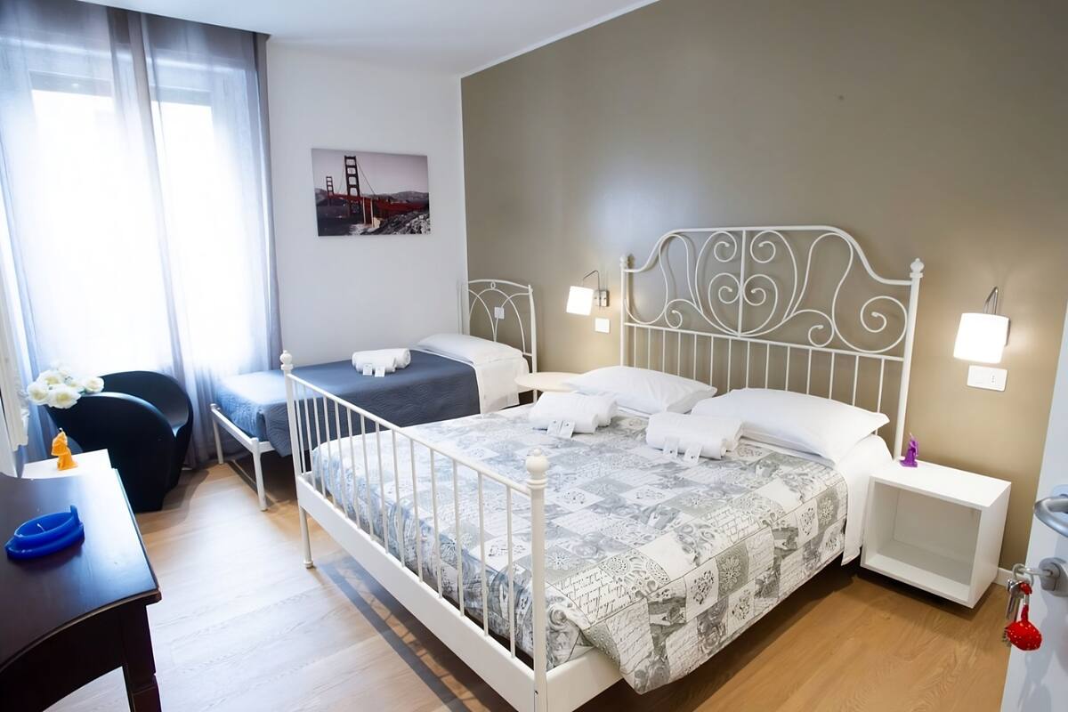Ein Hotelzimmer mit einem großen Bett, zwei Nachttischen, einem Schreibtisch und einem Sessel.