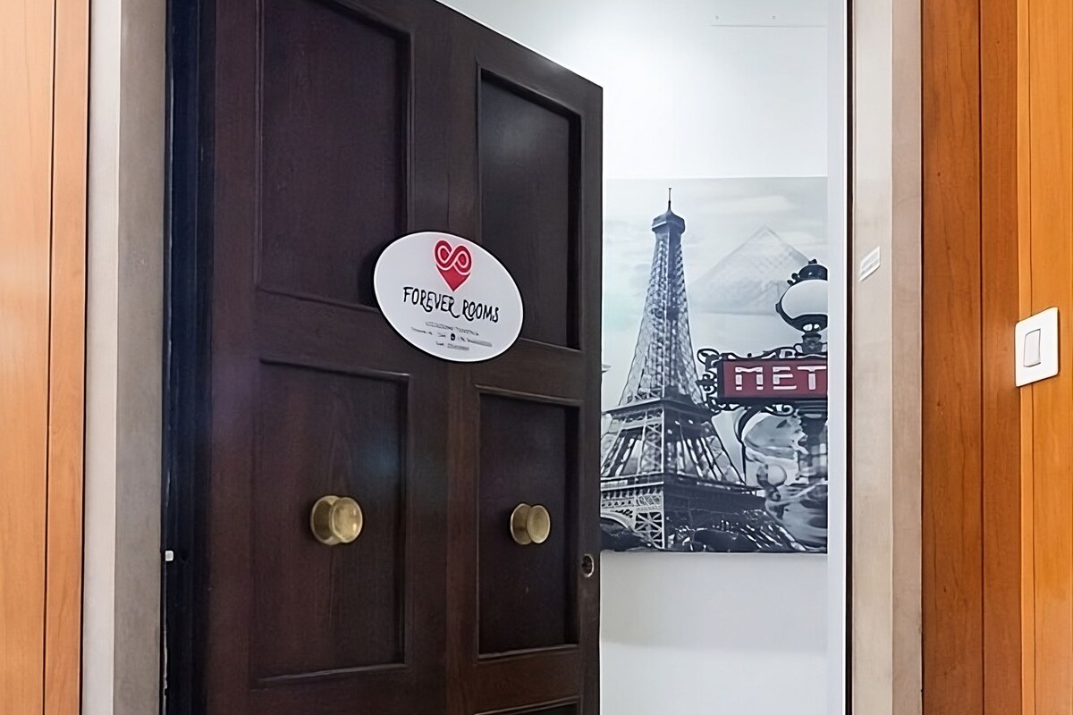 A dark wooden door with a sign that reads "Forever Rooms."