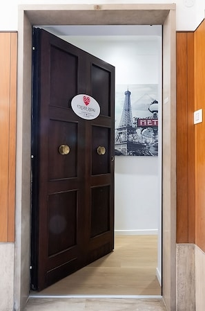 Une porte en bois sombre, sur laquelle est apposée une plaque portant l’inscription « Forever Rooms ».