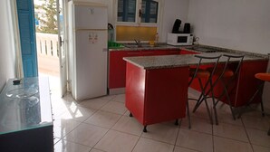 Une cuisine compacte équipée d’un réfrigérateur, d’un four à micro-ondes et d’un petit îlot avec des tabourets.