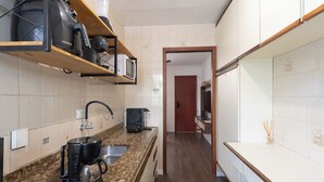 A modern kitchen with granite countertops, a coffee maker, a microwave, and a blender on a wooden shelf. - Apto c boa Localiza o Prox Centro pet Friendly (Jundiai)