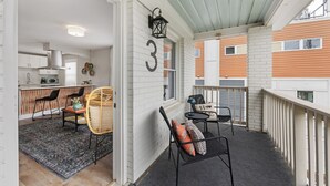 A covered porch with a dining area, a kitchen visible through an open door, and a number '3' on the wall.