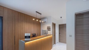 A reception desk with a wooden finish, a computer monitor, and a sign indicating 'BW Premier'. - Sokio Attiki Hotel, Bw Premier Collection (Athens)
