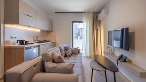 A modern living room with a sofa, a coffee table, and a TV mounted on the wall. - Sokio Attiki Hotel, Bw Premier Collection (Athens)
