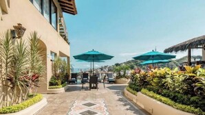 A patio area with outdoor seating, umbrellas, and a decorative pathway. - Scenic views in Downtown/Romantic Zone (Puerto Vallarta)