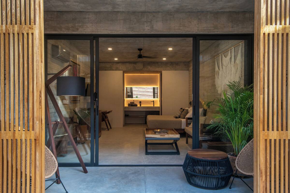 A modern interior with a sofa, coffee table, and chairs in a well-lit living area.