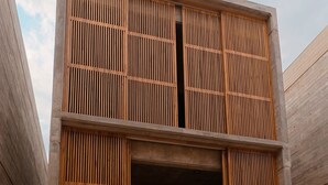 A modern building with a flat roof, large wooden slats, and a reflective water surface in front. - Hotel JILOO Petite Maison (Santa Maria Colotepec)