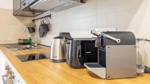 A modern kitchen with a built-in coffee machine, a kettle, and a toaster.
