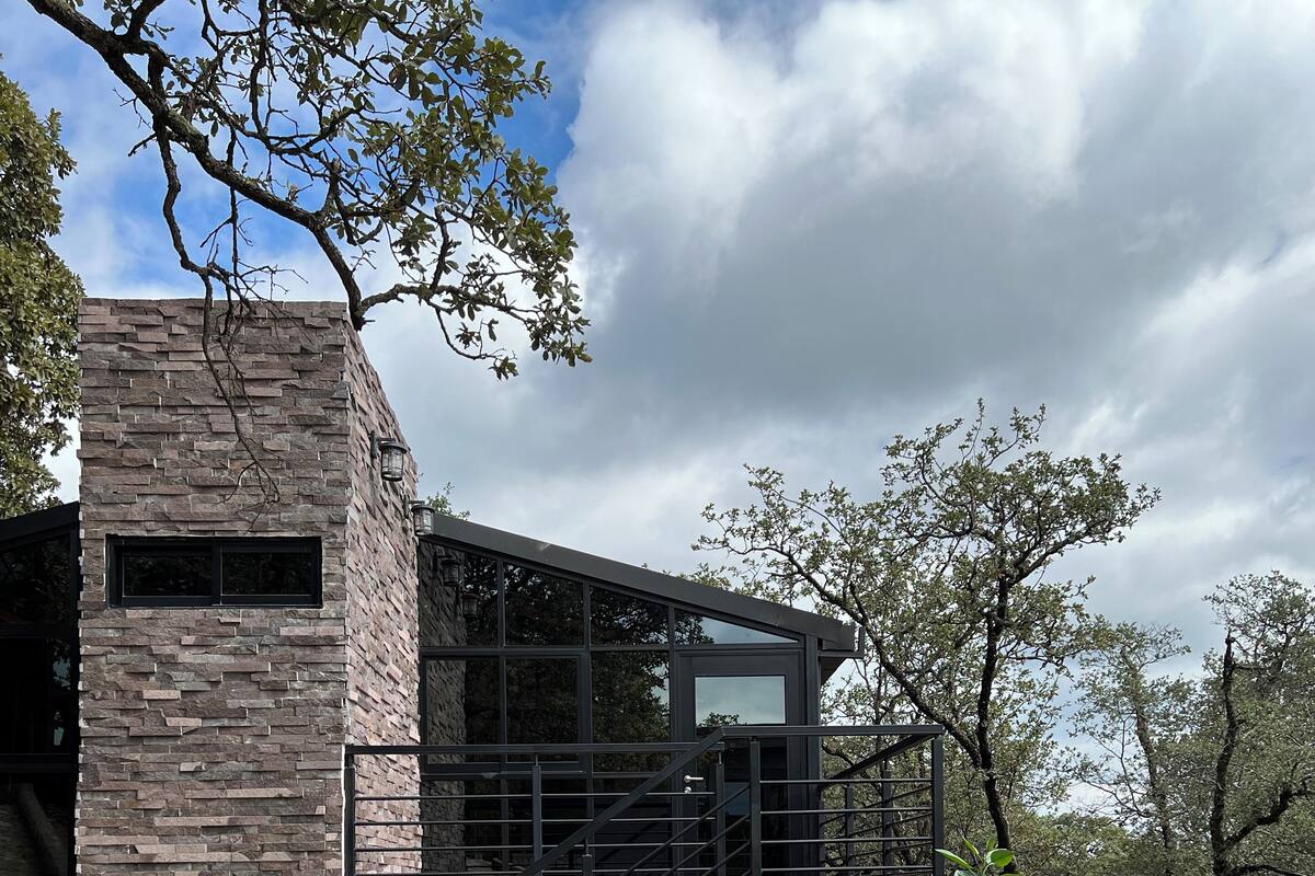 A modern building with a stone facade and a glass balcony.