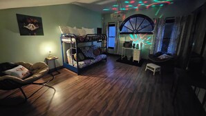 A room with a bunk bed, a desk with a computer, and a window with curtains. - Charming barn loft in quaint Marshall (Marshall)