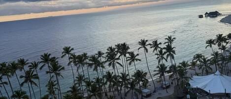 A resort with a pool, beach, and palm trees.