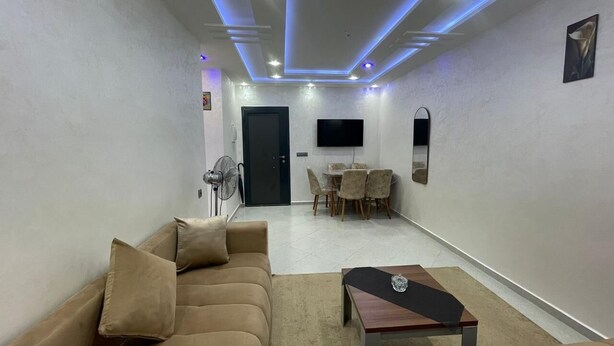 Uma sala de estar moderna com sofá, mesa de centro e área de jantar.