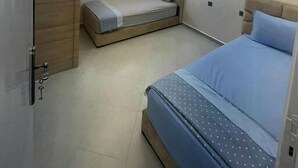 Quarto com cama, guarda-roupa e janela.
