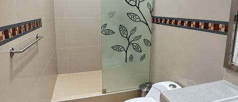 Ein Badezimmer mit Duschkabine, Toilette und Waschbecken.