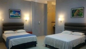 Two single beds with white linens, a nightstand, and wall-mounted lights. - Hotel Embassy Suites (Nauta)