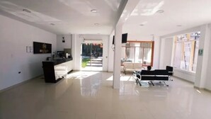 A spacious, modern hotel lobby with a reception desk, seating area, and large windows. - Hotel Embassy Suites (Nauta)