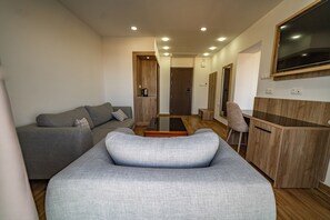A modern living room with a sofa, a coffee table, and a TV mounted on the wall. - Rais El Marsa (Algiers)