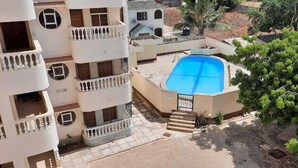 A residential building with a swimming pool, balconies, and surrounding greenery. - Waiyaki way Heights (Mombasa)