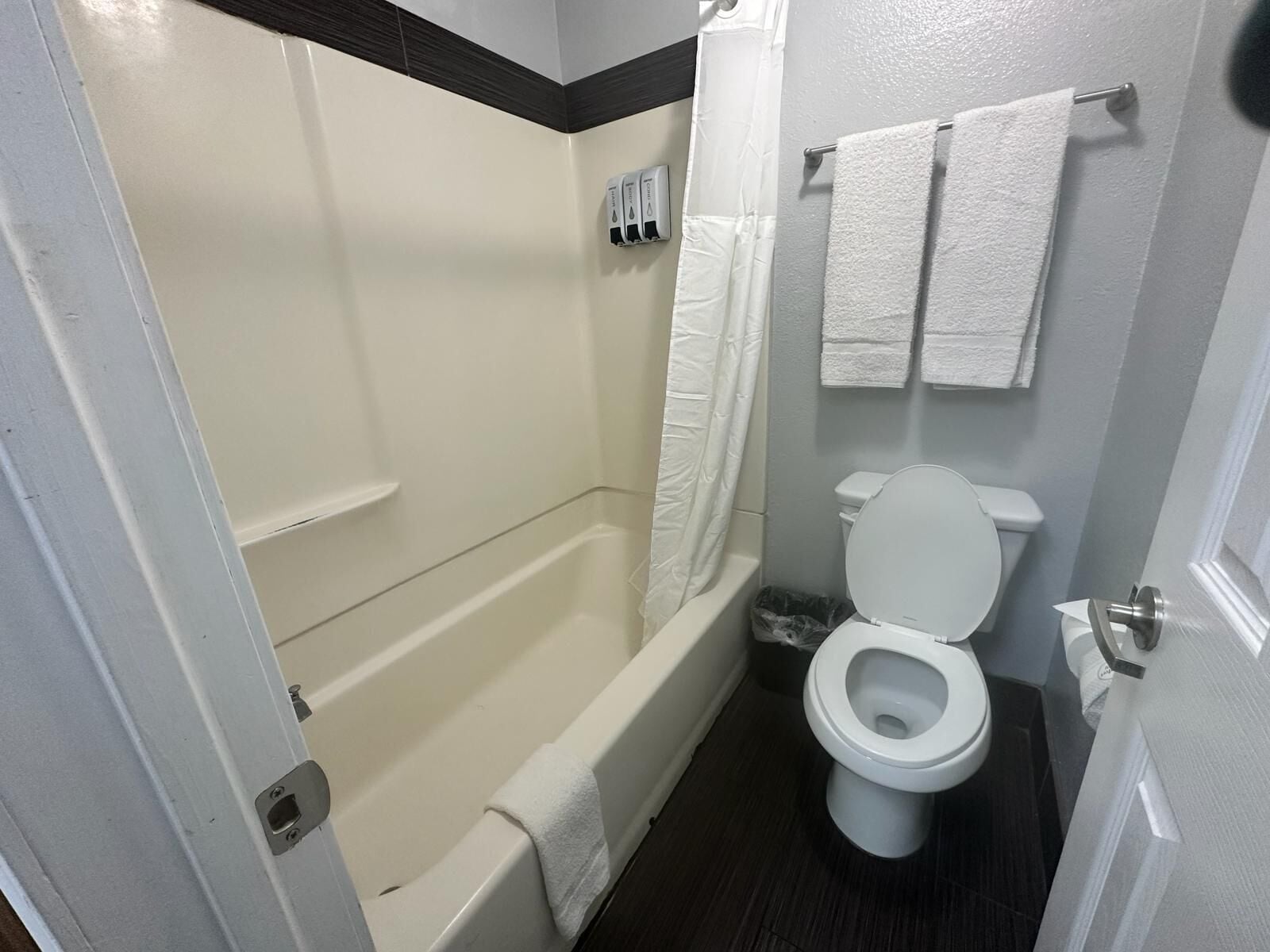 Un baño con bañera, inodoro y cortina de ducha.