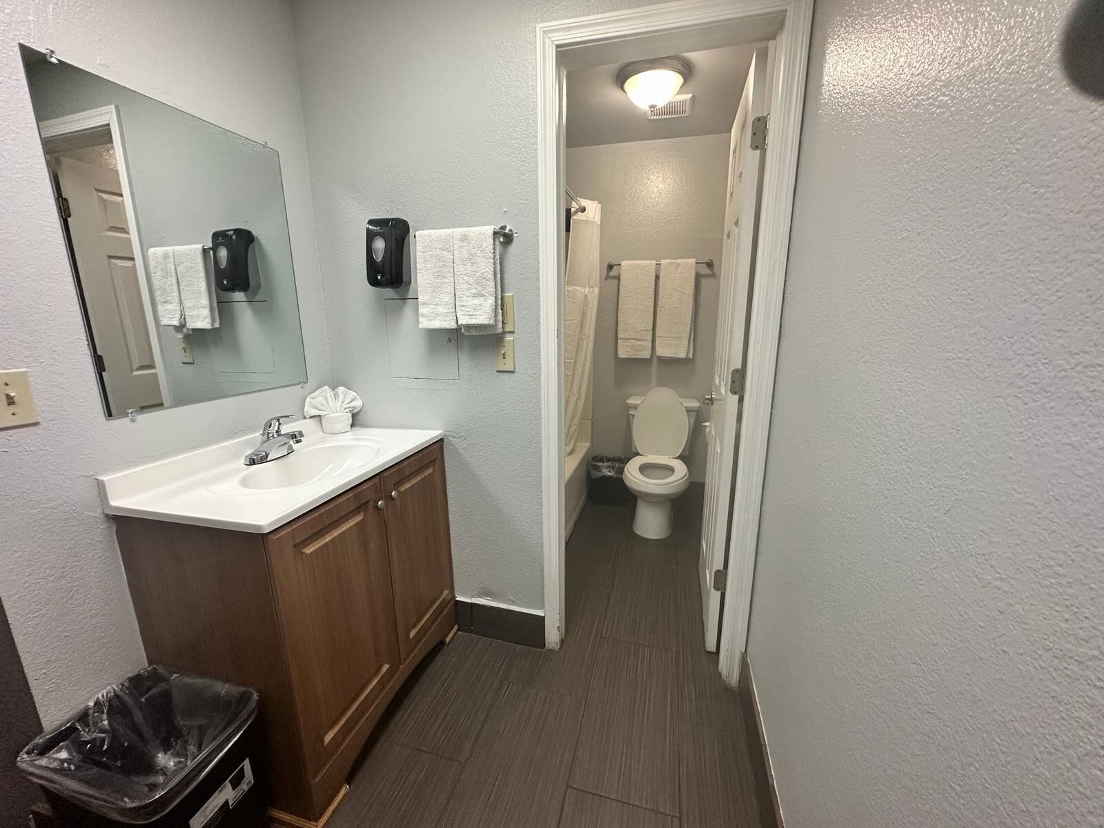 Un baño con lavabo, espejo, toallero y retrete.