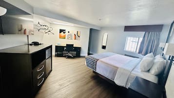 Una habitación de hotel moderna con cama, escritorio y armario.