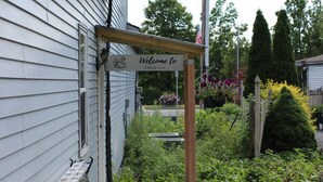 A wooden deck leading to a house with a 'Welcome to Swan' sign. - Luxury 2-bedroom apartment in excellent Manlius with WiFi, AC (Manlius)