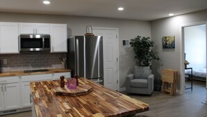 A modern kitchen with white cabinets, stainless steel appliances, and a wooden island. - Luxury 2-bedroom apartment in excellent Manlius with WiFi, AC (Manlius)