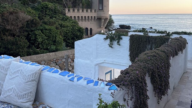 A coastal building with a tower, white walls, and blue accents.